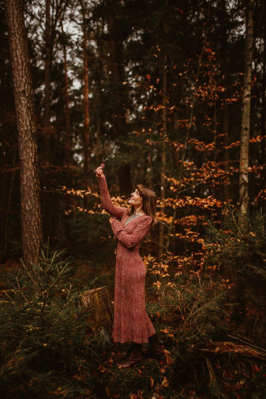 Anna beim Räuchern im Wald, Rauch steigt auf