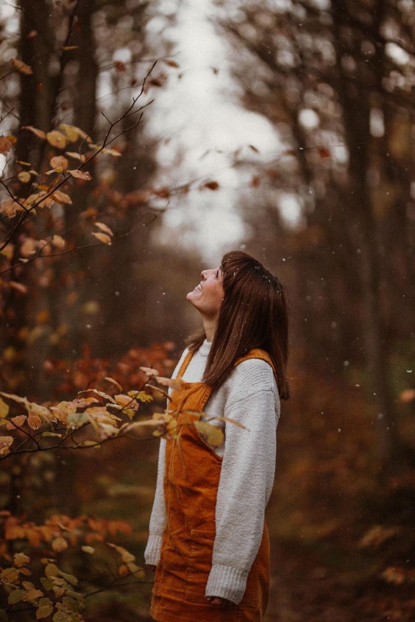 Anna blickt ins fallende Herbstlaub