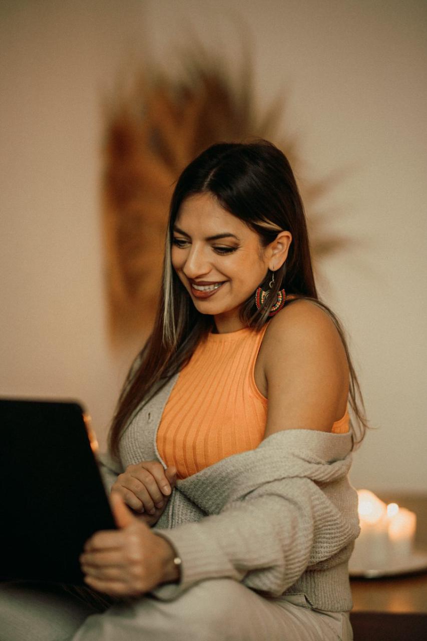 Maria lächelnd bei der Arbeit am Laptop