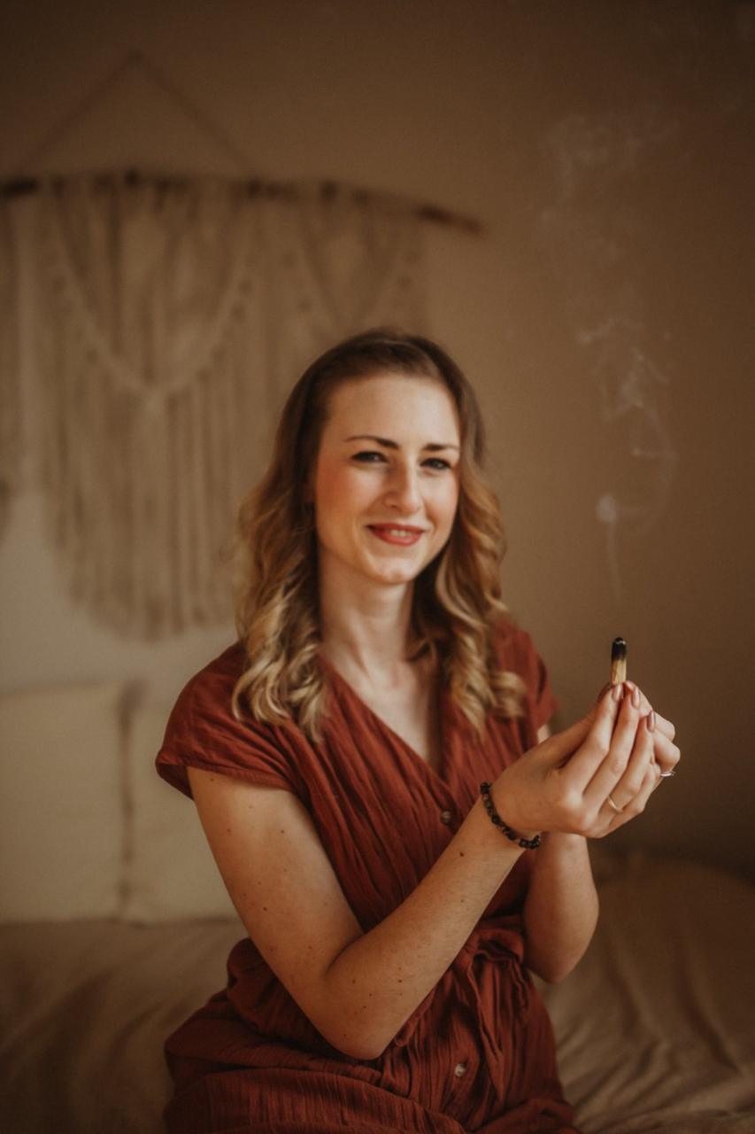 Sarah beim Räuchern mit Palo Santo, lächelnd