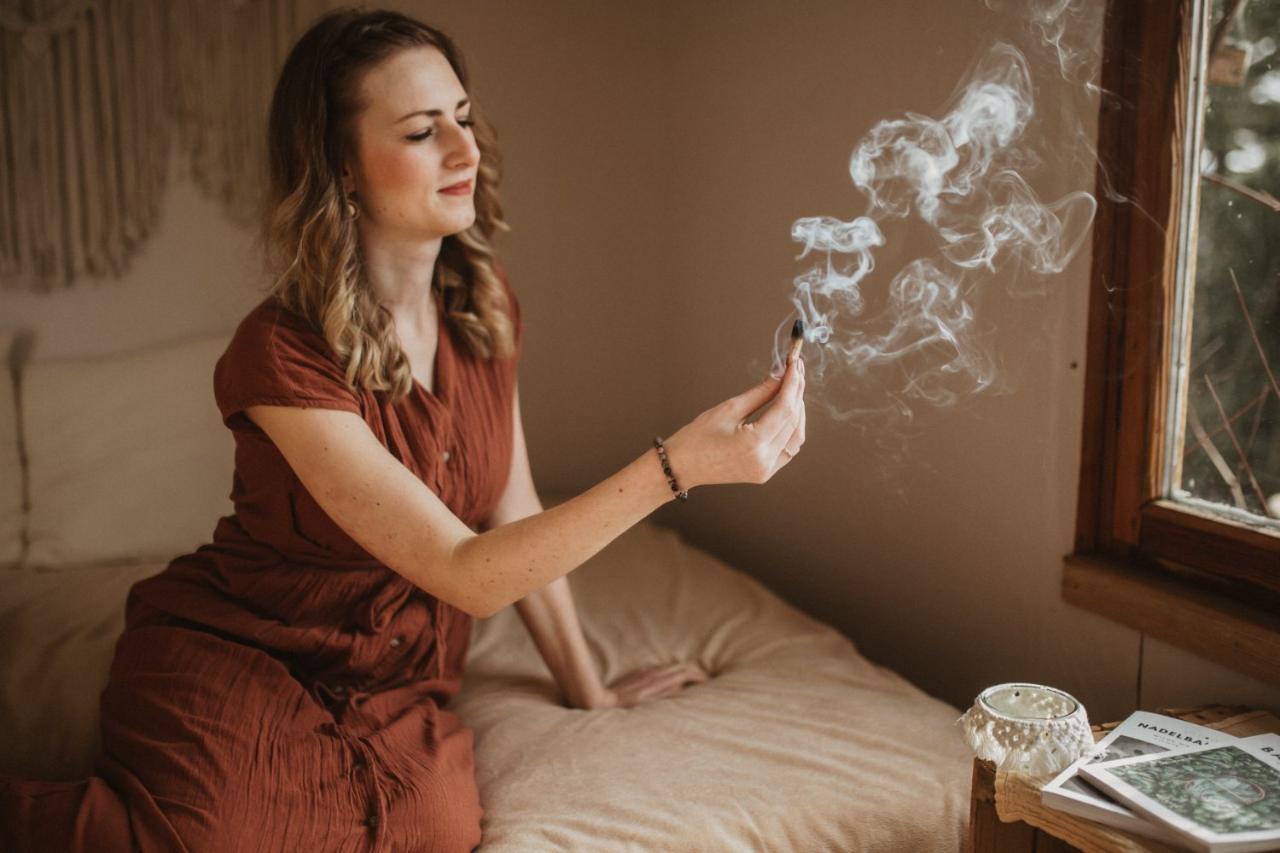 Sarah beim Räuchern mit Palo Santo im warmen Licht