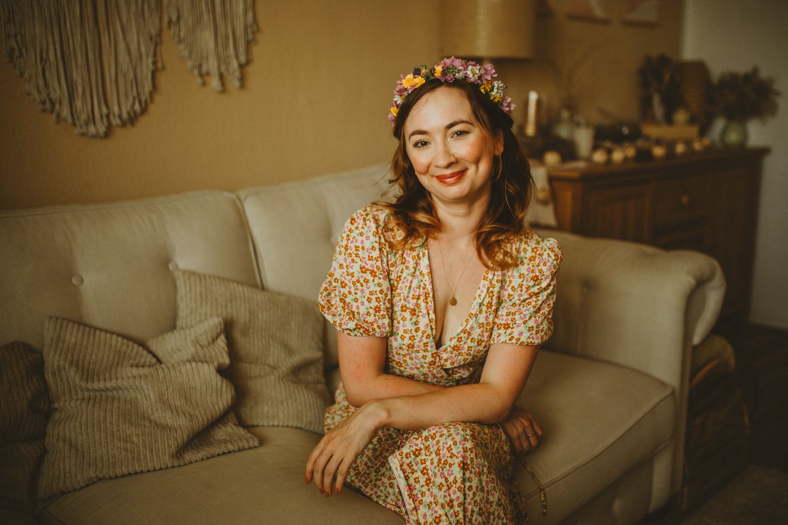 Vanessa mit Blumenkranz, lächelnd auf dem Sofa